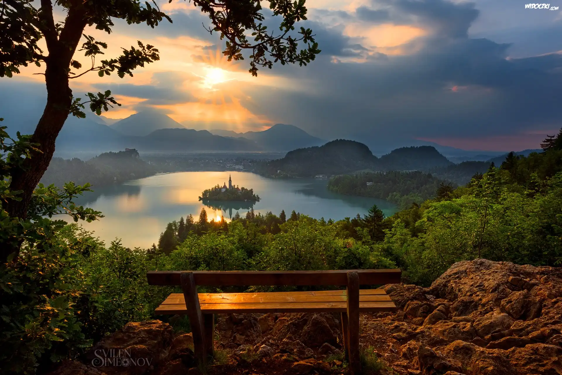 Słowenia, Blejski Otok, Góry Alpy Julijskie, Jezioro Bled, Ławka, Zachód słońca, Chmury, Drzewa