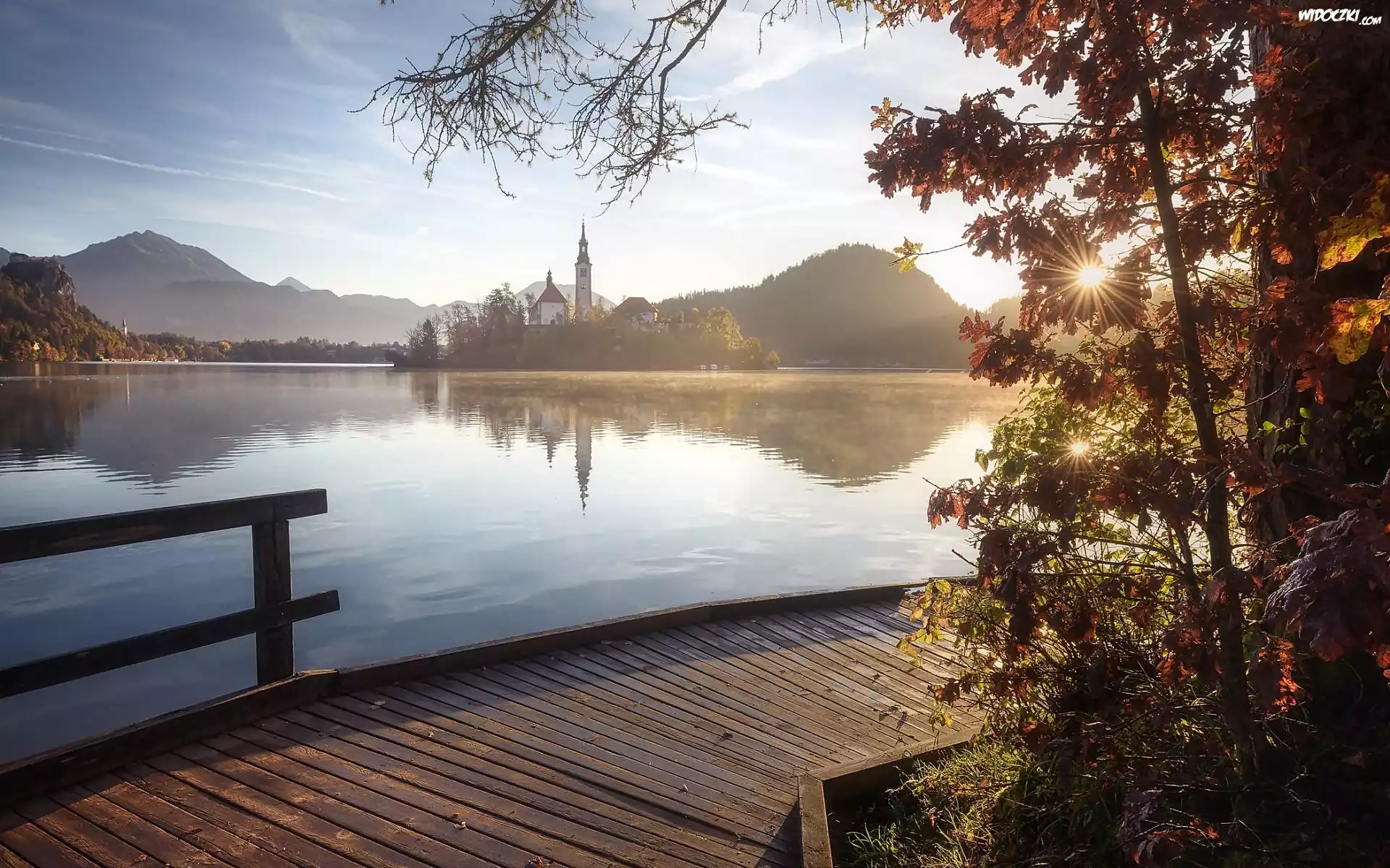 Słowenia, Jezioro Bled, Wyspa Blejski Otok, Kościół Zwiastowania Marii Panny, Góry Alpy Julijskie, Wschód Słońca, Pomost, Promienie słońca, Drzewa